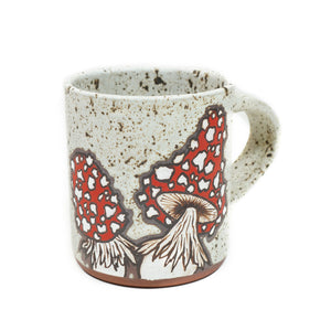 Wheelthrown red stoneware mug with a hand-painted mushroom motif & speckled white glaze 