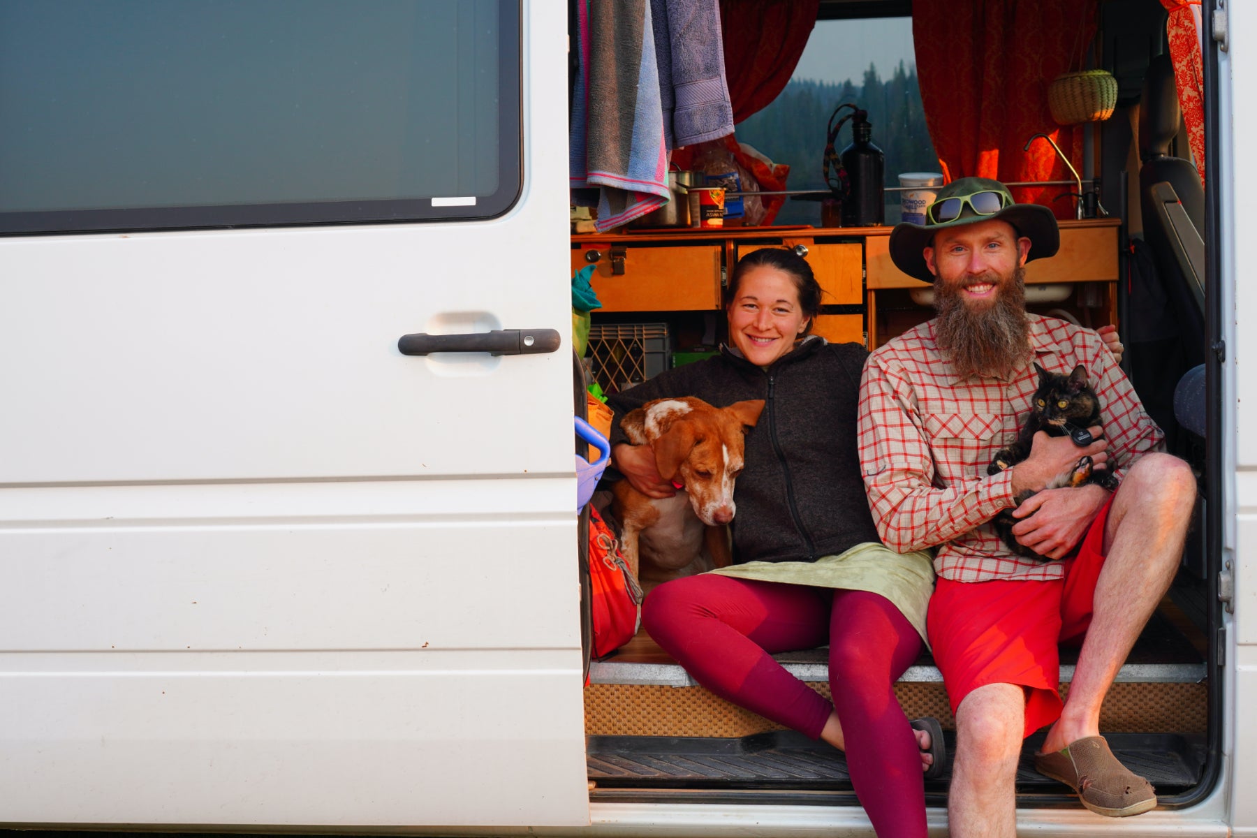 Craig, Britt, Kael Pup & Joone Cat sitting in doorway of van. We're the creative forces behind Living Large Small.